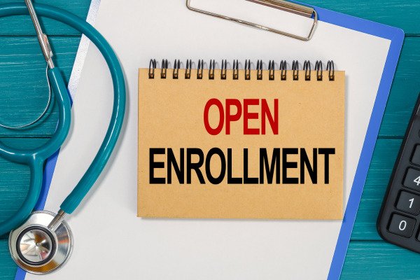 Sign reading 'Open Enrollment' for Knoxville, TN's Medicare Advantage program, highlighting key registration dates.